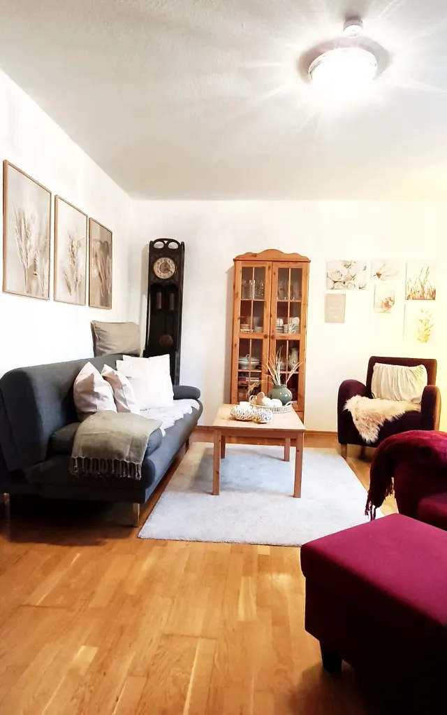 BookNoFees: alojamiento vacacional en Bensheim, Hesse, Alemania – Sala con un sofá azul, un armario de madera y un reloj de pie