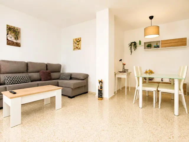 BookNoFees: alojamiento vacacional en Jerez De La Frontera – Sala con sofá gris y área de comedor con mesa de vidrio