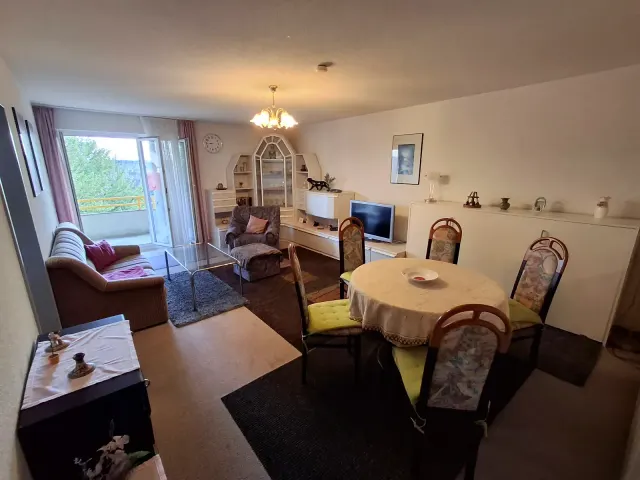 BookNoFees: alojamiento vacacional en Gailingen – Sala y comedor con sofá, mesa de comedor y acceso al balcón