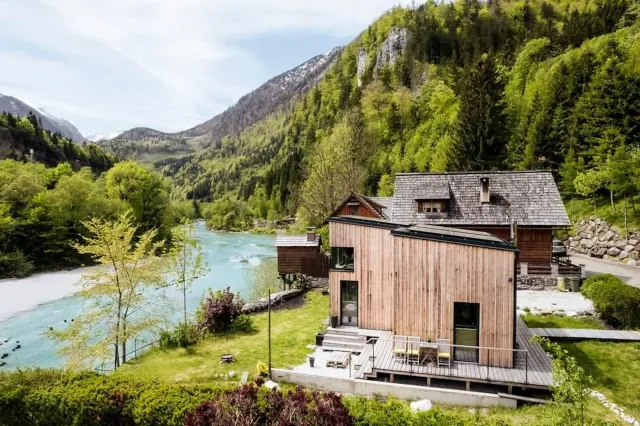 BookNoFees: alojamiento vacacional en Hieflau – Vista exterior de una casa de vacaciones de madera con el río y las montañas como telón de fondo