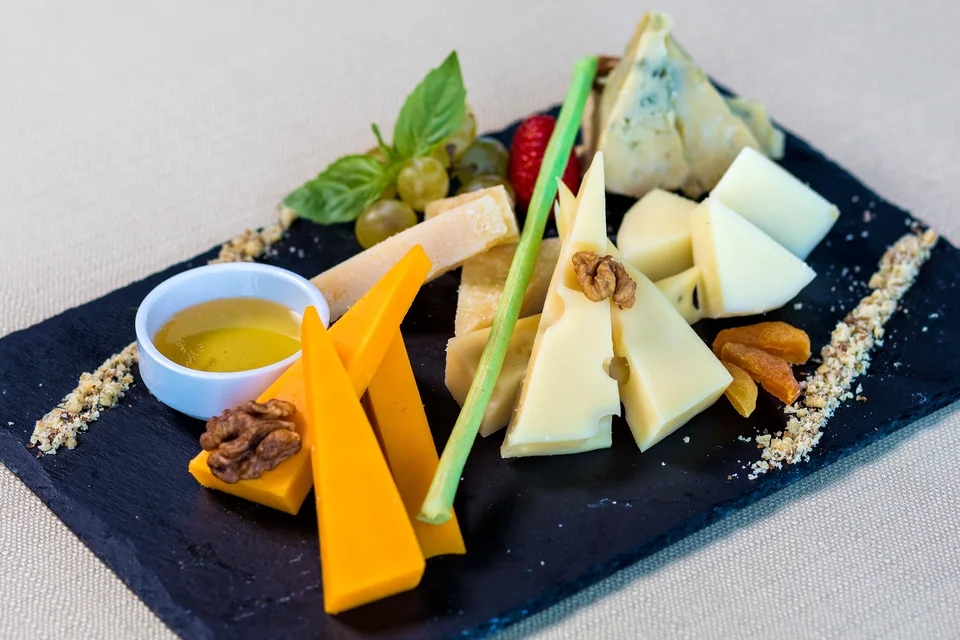 BookNoFees: Foto de ejemplo: Surtido de quesos con fruta y frutos secos en una tabla de servir